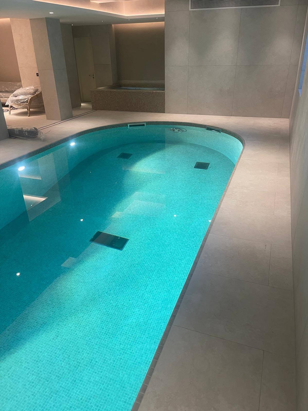 Indoor oval swimming pool with sealed stone coping joints
