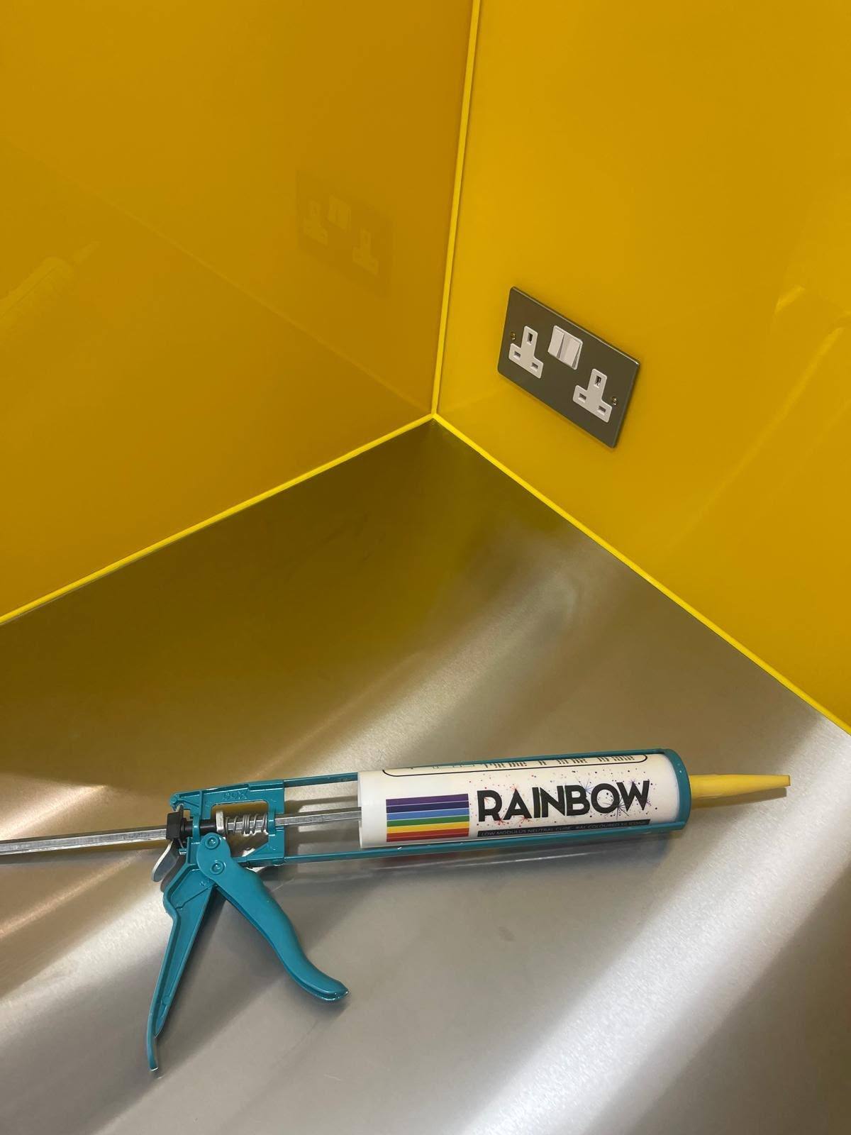 Colour-matched silicone sealant cartridge used beside a yellow glass splashback