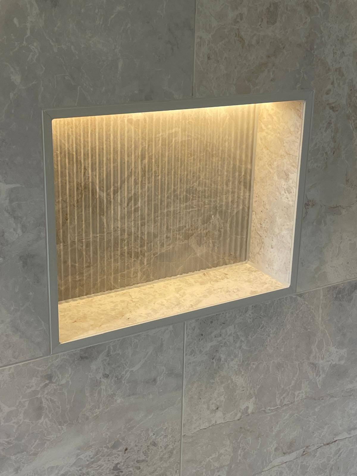 Illuminated shower tile niche with neatly sealed internal joints
