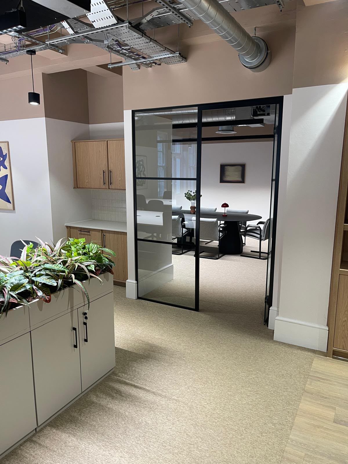 Glazed office partition and meeting room screen with acoustic sealant applied to the perimeter framing joints