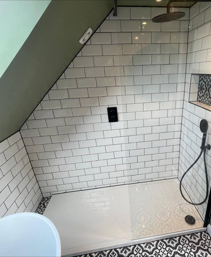 Sloped-ceiling shower with sealed white subway tile joints