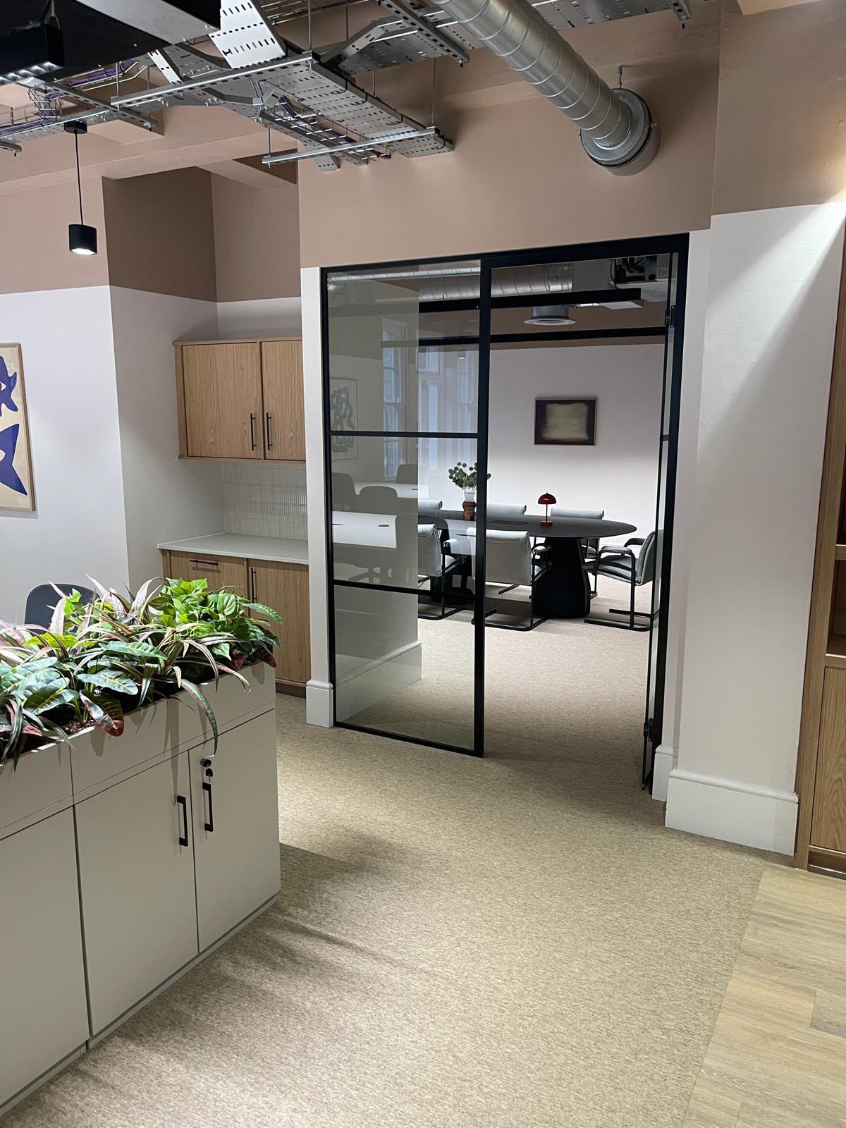 Office glazed partition and skirting joints resealed after old sealant removal