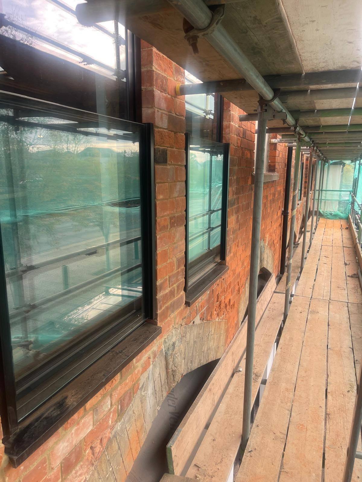 Scaffolded brick and glazed elevation before external sealant works
