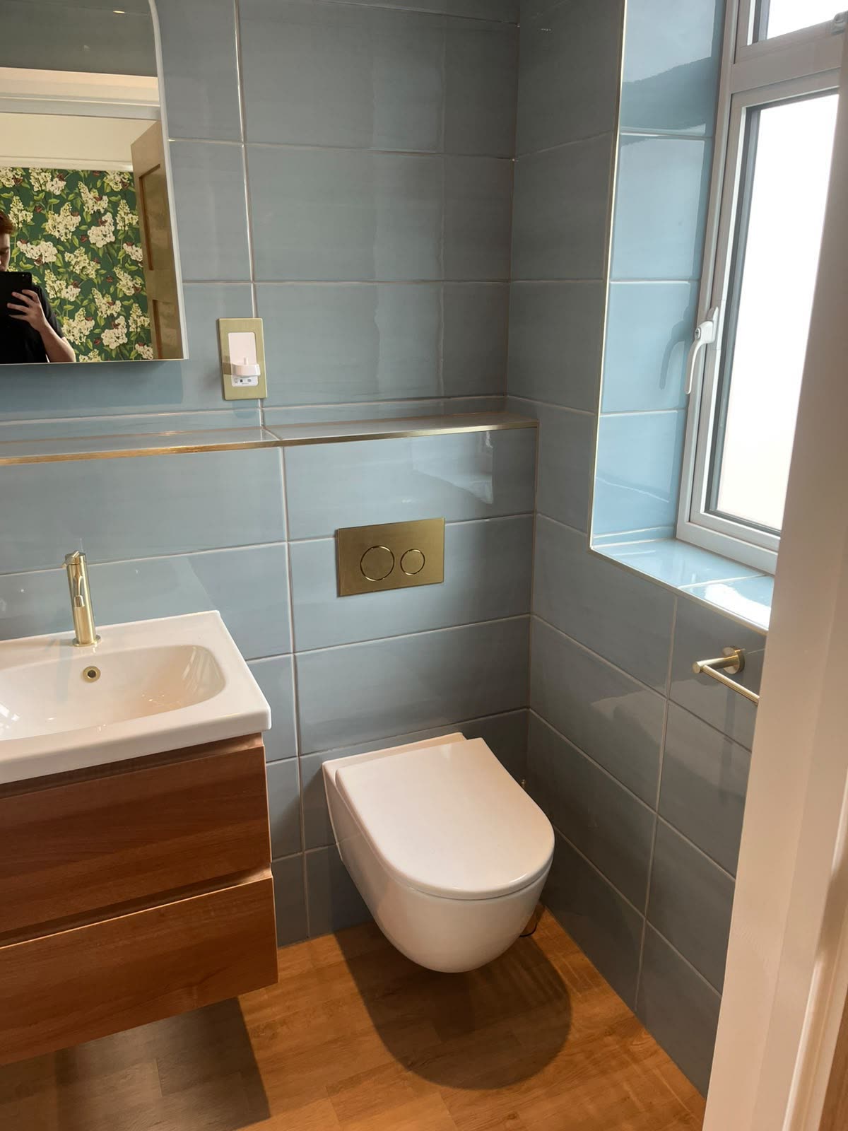 Blue-tiled cloakroom with wall-hung WC, basin and window reveal neatly silicone sealed